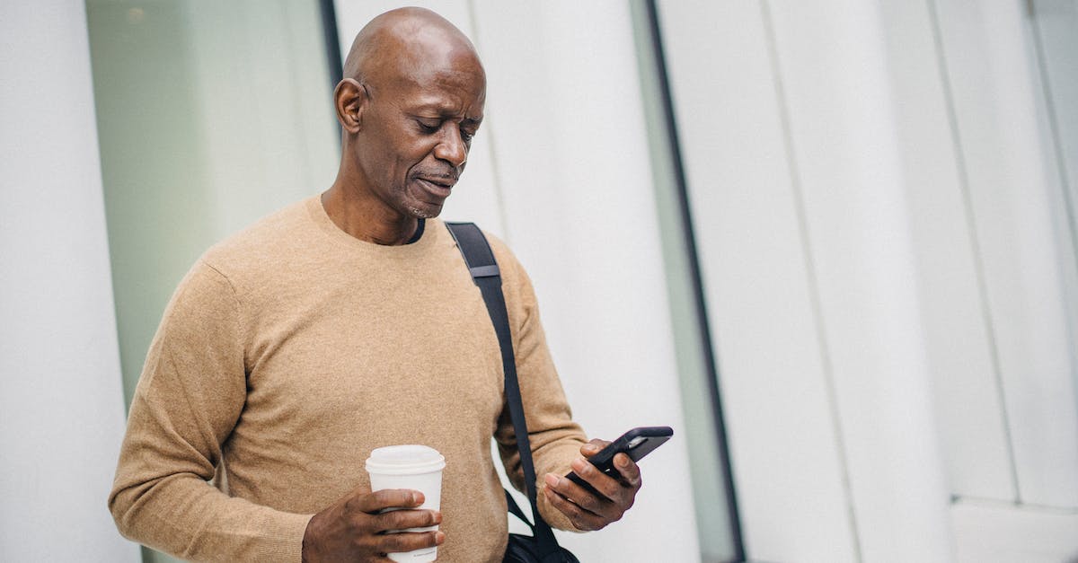 How to configure Media center (Wi-Fi) on the PS4? - Serious black man with smartphone and takeaway coffee