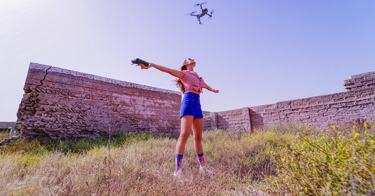 How to control Gandalf "flying bricks"? - Fit woman standing with arms outstretched under flying drone