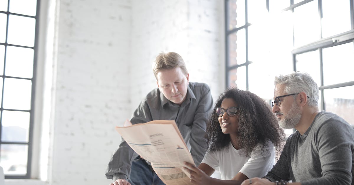 How to copy a main level to editor - Group of journalists of different ages in informal clothes doing paperwork while spending time together in modern workspace together in daytime