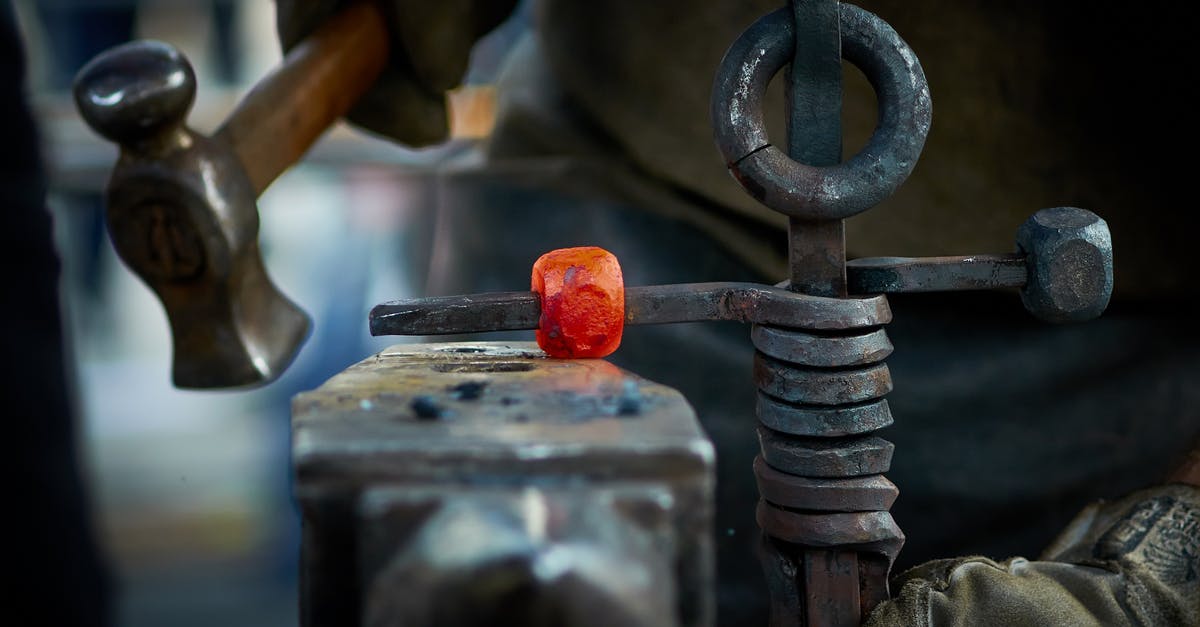 How to create compressed iron without explosions? - Crop man forging metal in smithy