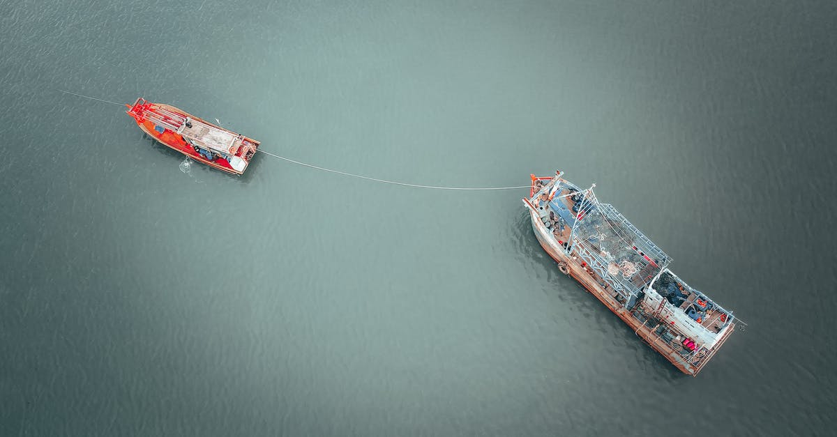 How to detach the tow cable? - Fishing boats connected with rope on river