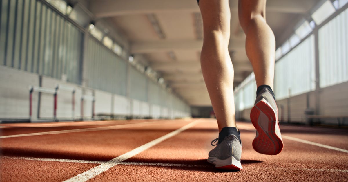How to determine the right sword? - From below back view of crop strong runner walking along running track in athletics arena while doing warm up exercises during workout