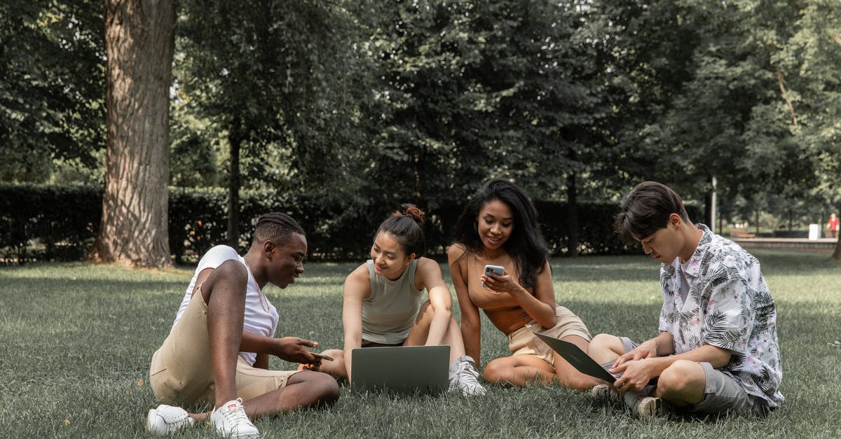 How to effectively keep a laptop cool while running a server? [closed] - Group of diverse friends browsing laptops and mobile phone while spending time in park