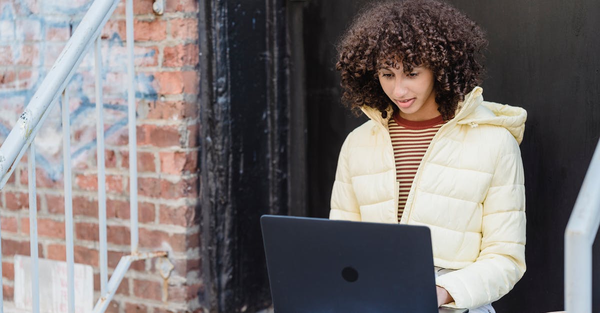 How to effectively keep a laptop cool while running a server? [closed] - Young ethnic self employed lady with curly hair in trendy outfit sitting on stairs of aged brick building and typing on laptop