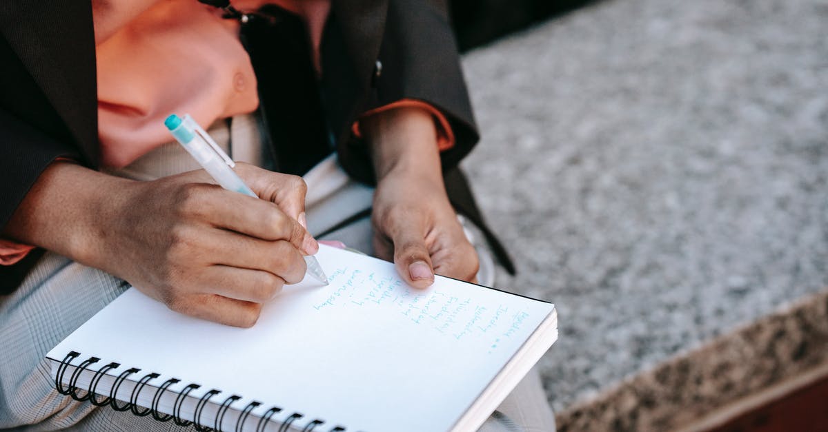 How to execute list of commands? - From above of crop anonymous ethnic woman making list in notebook during work in park