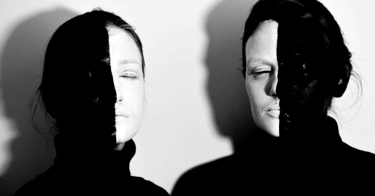 How to fight in close quarters without alerting the guards? - Black and white of models with face covered with black and white paints standing with closed eyes against white background How to fight in close quarters without alerting the guards? - Black and white of models with face covered with black and white paints standing with closed eyes against white background