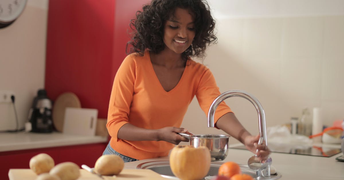 How to fill a black soul gem? [duplicate] - Smiling young ethnic lady in colorful casual clothes standing near sink and pouring water in pot while cooking food in spacious modern kitchen at home