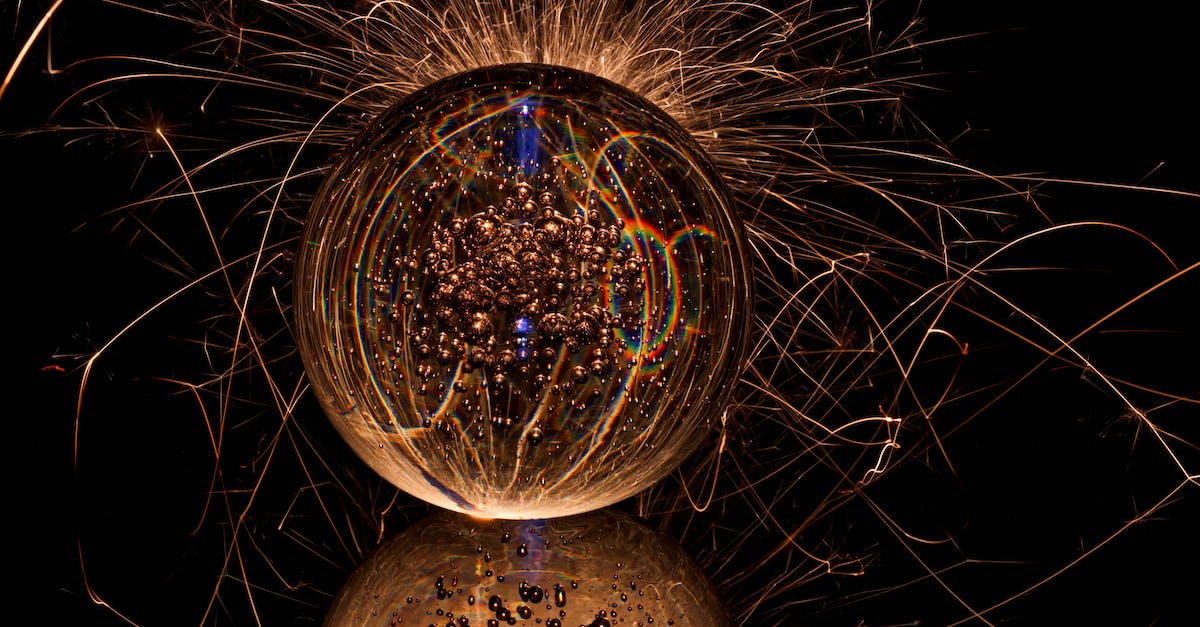 How to find a golden dropping fossil? - Abstract bright drop with refraction of golden gleams on sparkle background on dark surface with reflection and rays of light