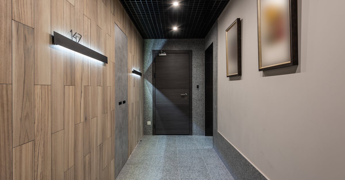 How to find the number of dwellers in a room? - Interior of hallway with illuminated numbers of hotel rooms hanging on wall near doors How to find the number of dwellers in a room? - Interior of hallway with illuminated numbers of hotel rooms hanging on wall near doors