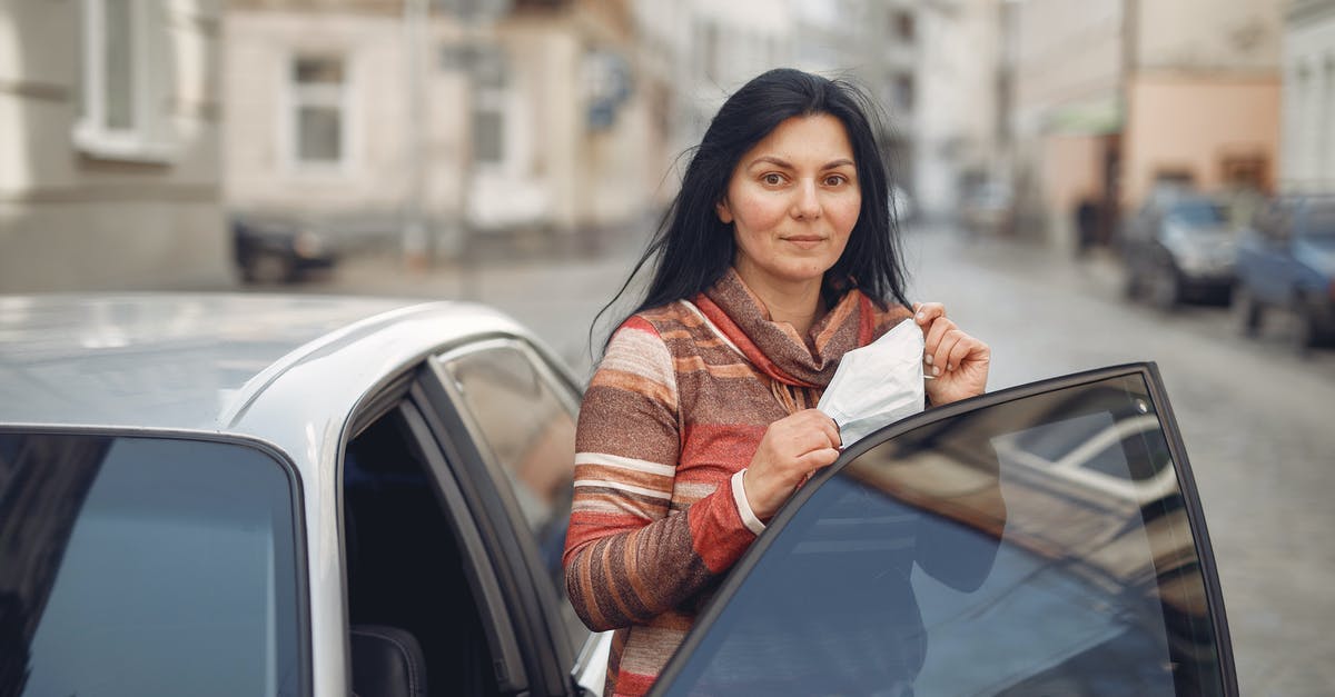 How to get rid of zombie villagers in a world - Content young woman with medical mask in hands standing near car on urban street