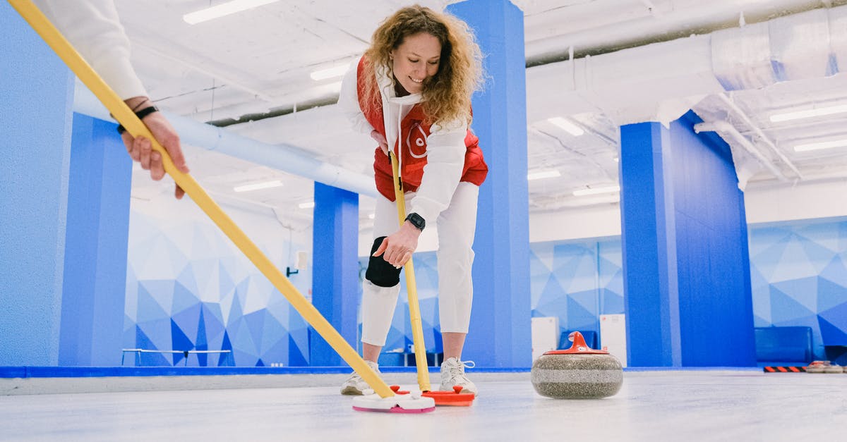 How to /give a player a named item with Level 10 enchants in Pocket/Bedrock Edition? [duplicate] - Ground level of cheerful woman and crop curler with curling brooms sweeping ice sheet in front of rock during training on rink