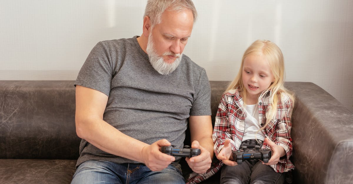How to hold Gamepad FIFA 15 - Elderly Man and a Little Girl Sitting on Leather Sofa How to hold Gamepad FIFA 15 - Elderly Man and a Little Girl Sitting on Leather Sofa