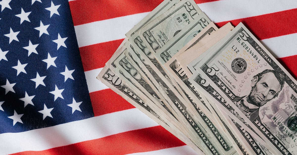 How to identify the capital of a nation - Top view of various dollar banknotes placed on flag of United States of America