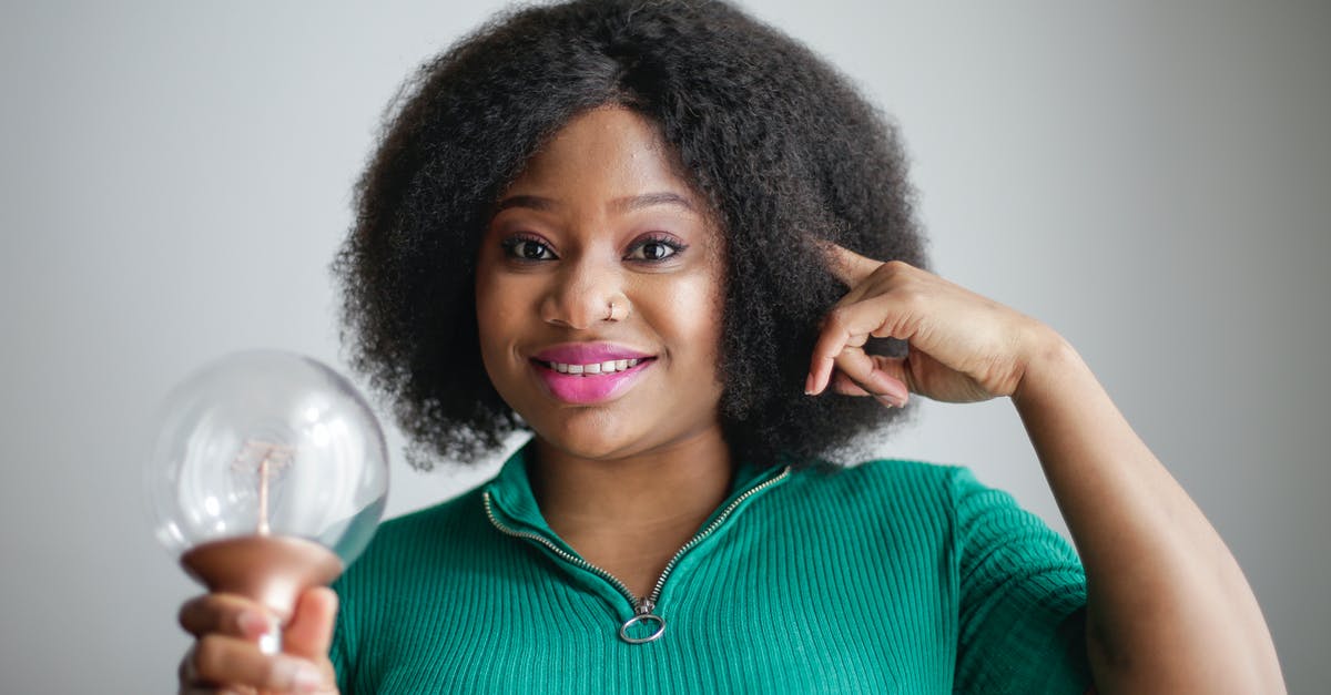 How to improve Power skill? - Positive young African American lady holding light bulb in hand on gray background