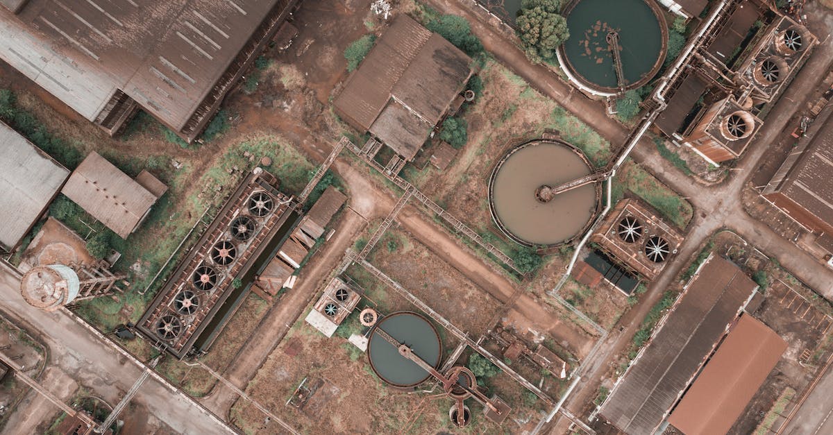 How to increase station storage? - Drone view of shabby factory with round settling tanks with mechanical means removing solids in water treatment plant