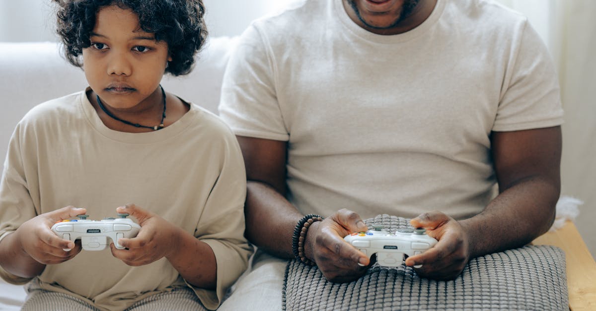 How to install the same game in a Switch console with a parent account and a second Switch console with a child account? - Crop ethnic male parent and son sitting near each other on sofa while using playstation and joysticks playing video games How to install the same game in a Switch console with a parent account and a second Switch console with a child account? - Crop ethnic male parent and son sitting near each other on sofa while using playstation and joysticks playing video games