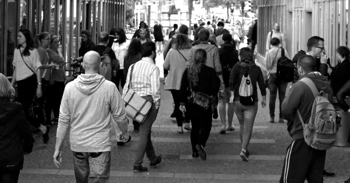 How to keep population happy? - Grayscale Photography of People Walking Near Buildings