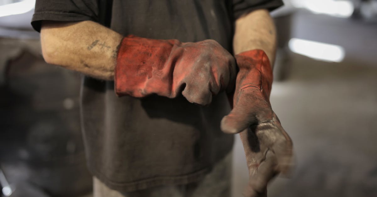 How to launch Technic from flashdrive - From above of crop male fitter in shabby heavy duty gloves in workshop