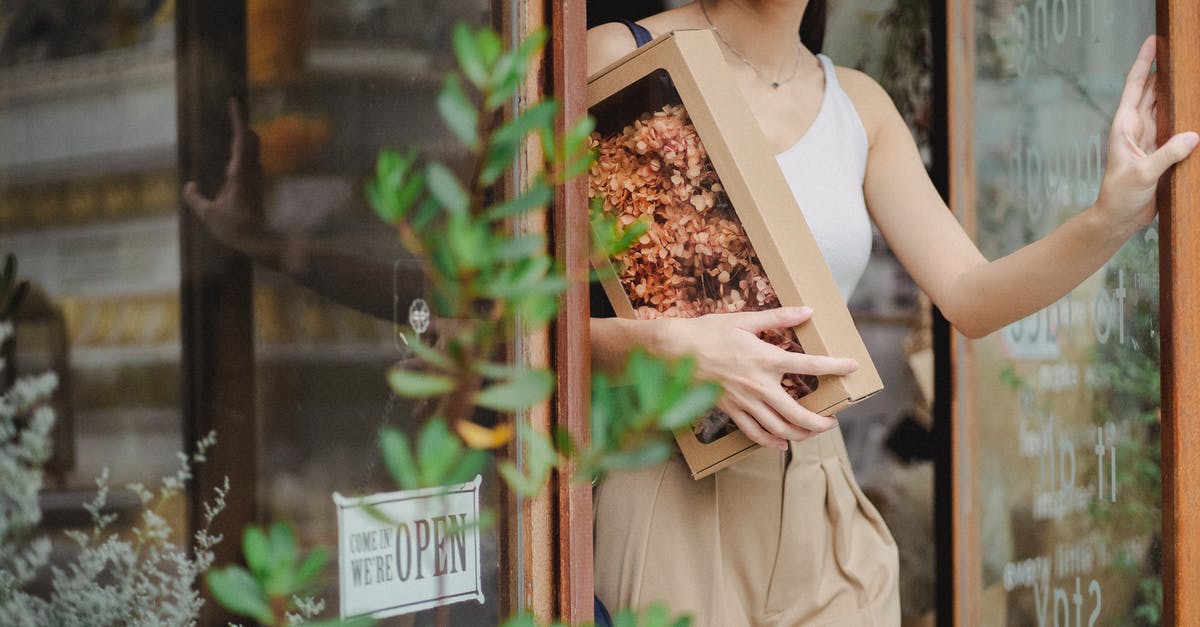 How to leave a squad? - Crop glad woman with dried flowers box leaving floristry store How to leave a squad? - Crop glad woman with dried flowers box leaving floristry store