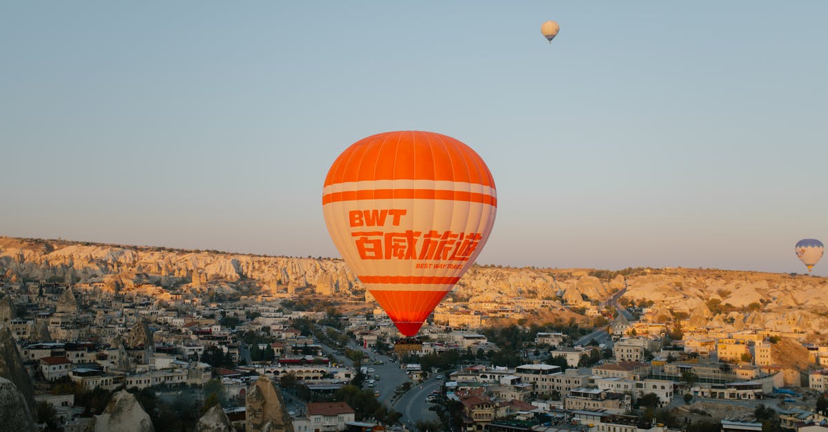 How to make a large area air [duplicate] - Orange hot air large balloon landing in old eastern town on summer evening