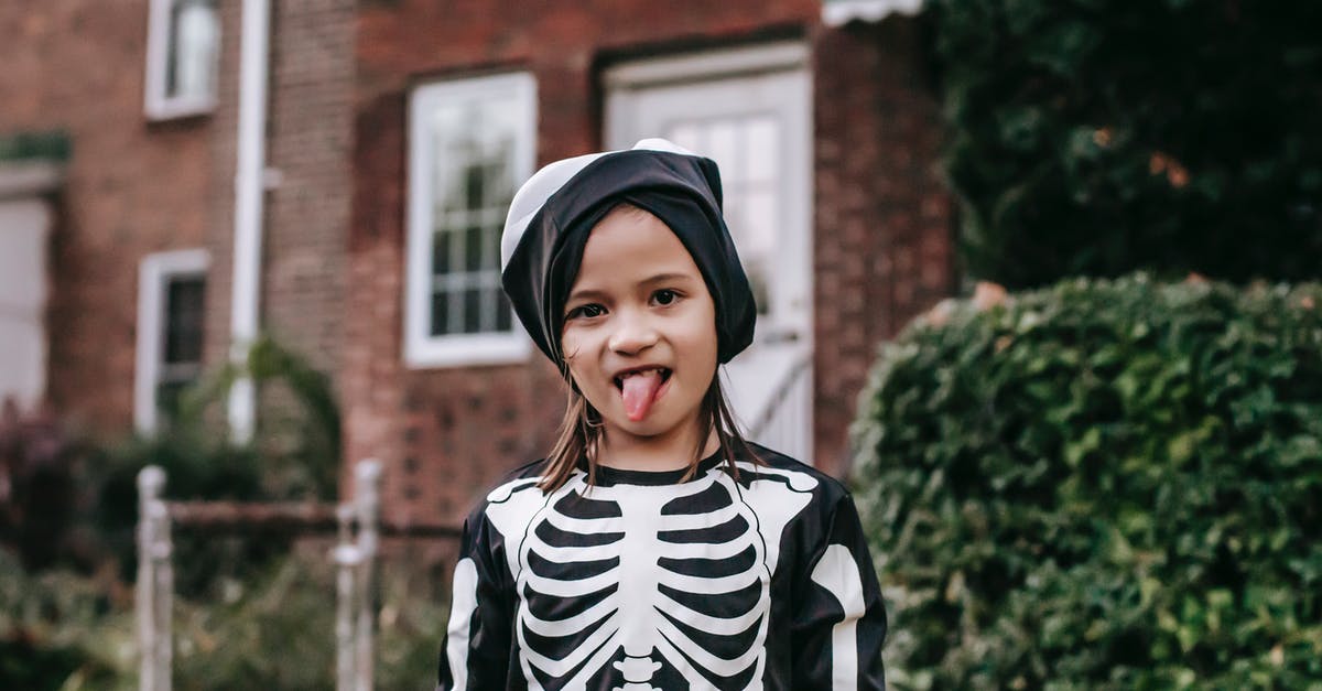 How to make an armoured zombie filter? - Funny girl in skeleton costume and mask on head showing tongue while standing on street in Halloween day and looking at camera