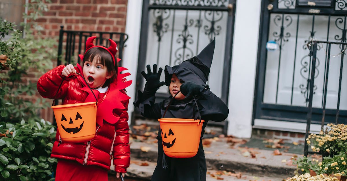 How to Make Black Weapons? - Funny children in witch and devil costumes carrying buckets for candies and showing creepy grimaces against house in neighbourhood
