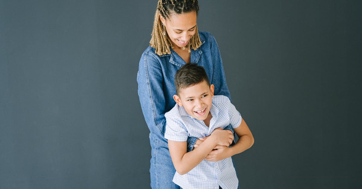 How to make two people play at the same time? - Woman in Demin Clothing Hugging Young Boy from Behind How to make two people play at the same time? - Woman in Demin Clothing Hugging Young Boy from Behind