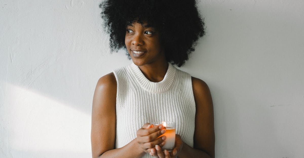 How to make zombies/skeletons not burn in sunlight without changing their looks? - Gentle African American female with curly hair standing with aromatic burning candle in glass at home and looking away How to make zombies/skeletons not burn in sunlight without changing their looks? - Gentle African American female with curly hair standing with aromatic burning candle in glass at home and looking away