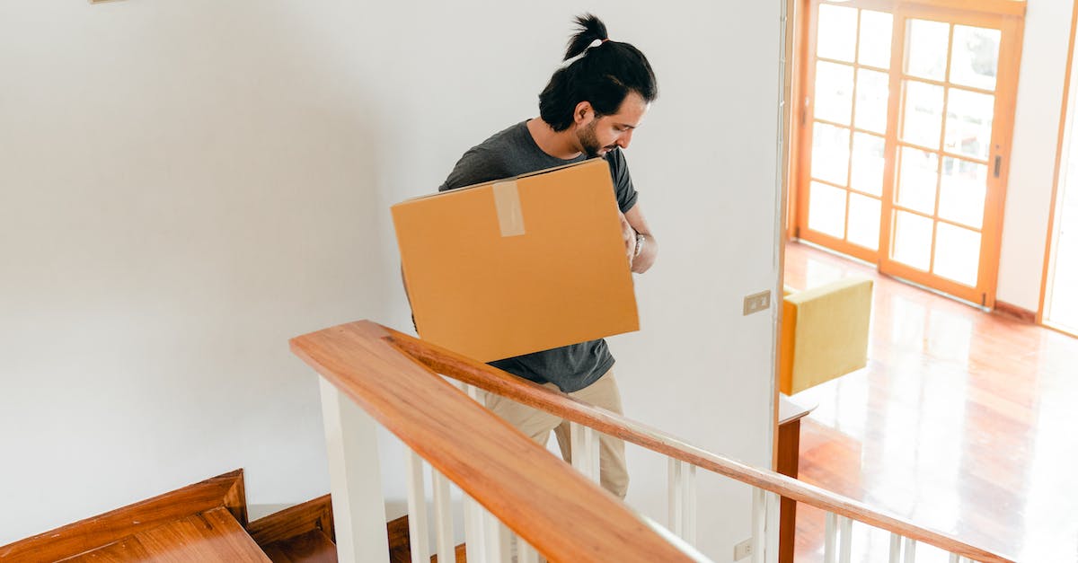 How to move items in a furnace only when there is space? - From above of full length male in casual clothes carrying carton box down stairs while moving personal items to new house How to move items in a furnace only when there is space? - From above of full length male in casual clothes carrying carton box down stairs while moving personal items to new house