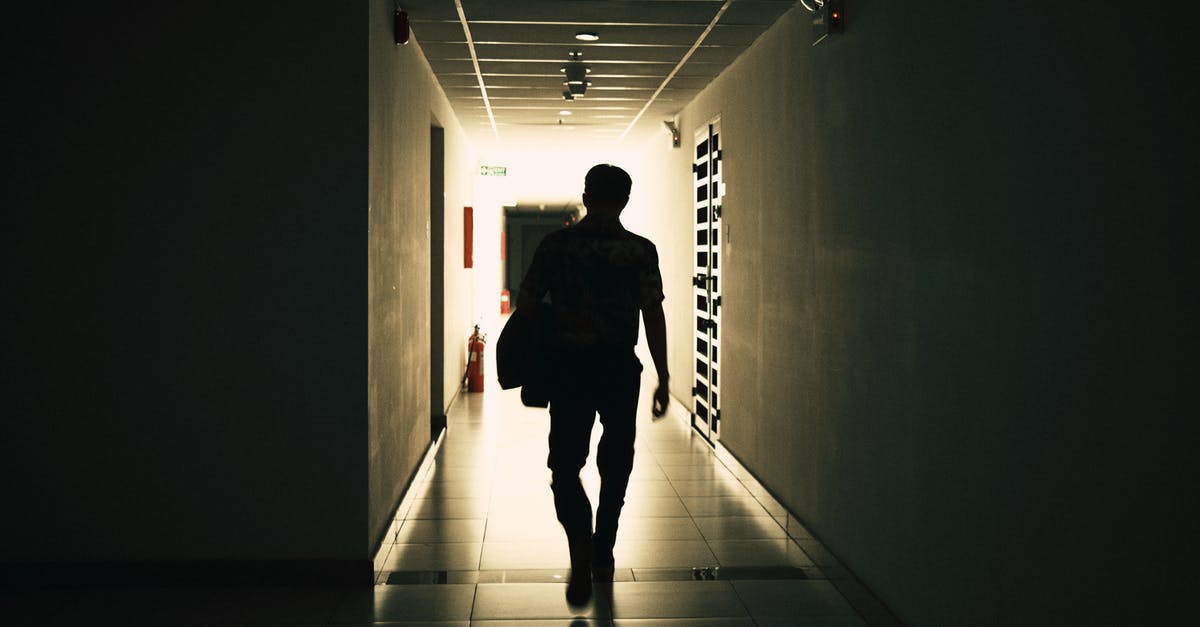 How to move office - Back view silhouette of unrecognizable male walking on narrow empty hall of modern building How to move office - Back view silhouette of unrecognizable male walking on narrow empty hall of modern building