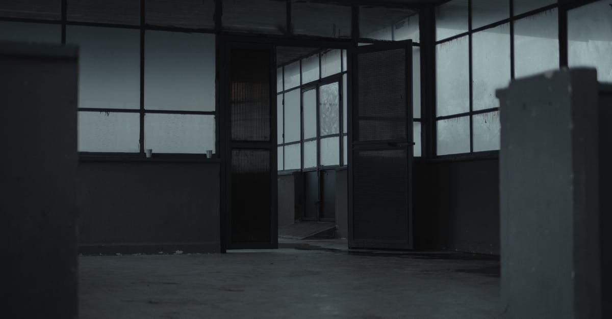 How to open locked door to Frifle and the Grey Mauser? - Interior of spacious empty room of gloomy abandoned building with glass windows and opened door