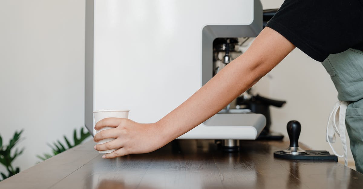 How to pass the "Key To Her Heart" mission (Hot Coffee mod)? - Crop unrecognizable female barista in black shirt and apron standing near modern professional coffee machine and passing white  takeaway paper cup with hot beverage across wooden table in coffee shop