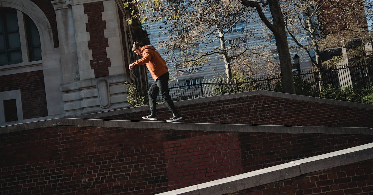 How to pick up the walkie talkie in Walking Dead Season 2: Episode 3? - Man walking on brick building parapet