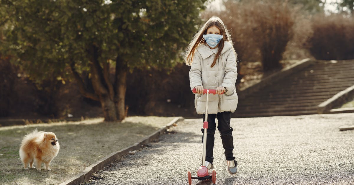 How to play it safe in Fortnite? [closed] - Full length of little girl in mask riding scooter while walking pet in nature