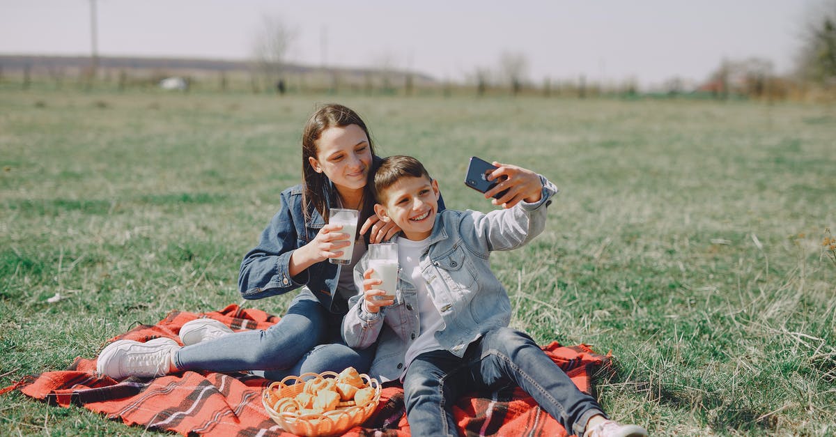 How to play missions online with a friend - Cheerful friends taking selfie on smartphone in countryside