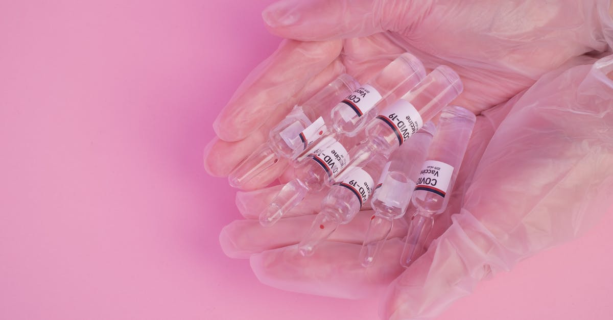 How to prevent bodies from disappearing in the original Half-Life? - Top view of crop faceless female doctor in latex gloves demonstrating heap of ampoules with COVID vaccine against pink background