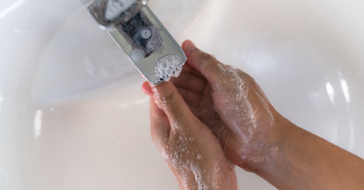 How to prevent water from freezing - Crop person washing hands over white sink
