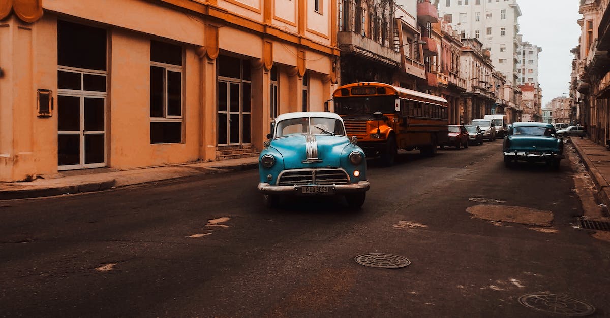 How to profit on vehicles - Teal Car Parked Beside Brown Concrete Building