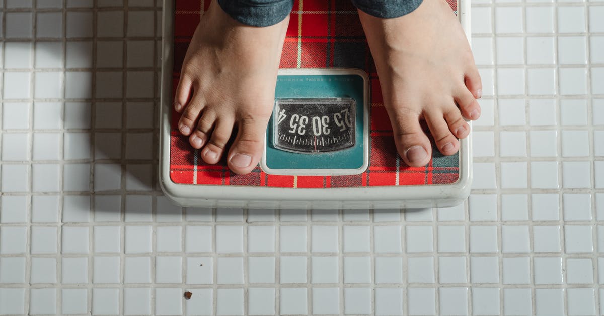 How to pull the mass of a subgrid (or total mass of all connected grids) into a programmable block script? - From above crop anonymous barefoot child in jeans standing on weigh scales on tiled floor of bathroom