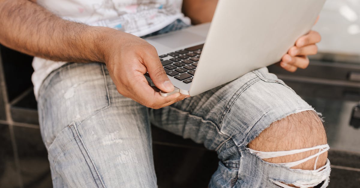 How to reconfigure a Flash Drive for use with XBox and the PC? - Man using laptop with flash drive