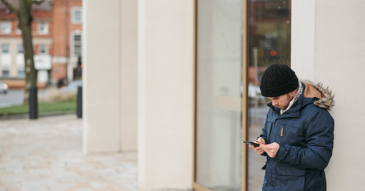 How to re-enter town after stealing? [duplicate] - Concentrated man in warm outwear standing on city street near building and browsing smartphone in daytime