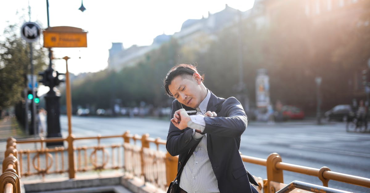 How to reliably measure the time it takes to recenter after firing in Call of Duty? - Photo of Man in Blue Blazer and Striped Shirt Standing by Stairs While on the Phone and Looking at His Watch