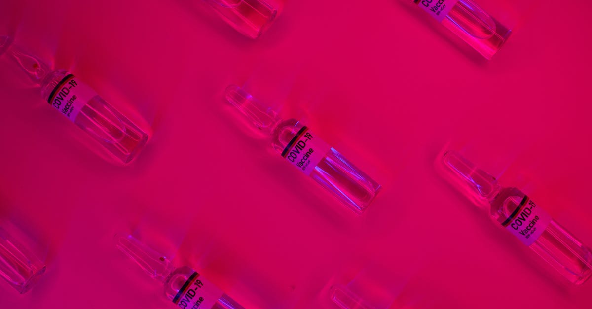 How to repeat glitch that turns med vendors into gun vendors? - Layout of doses of coronavirus vaccine in glass transparent vials placed on bright fuchsia background in studio