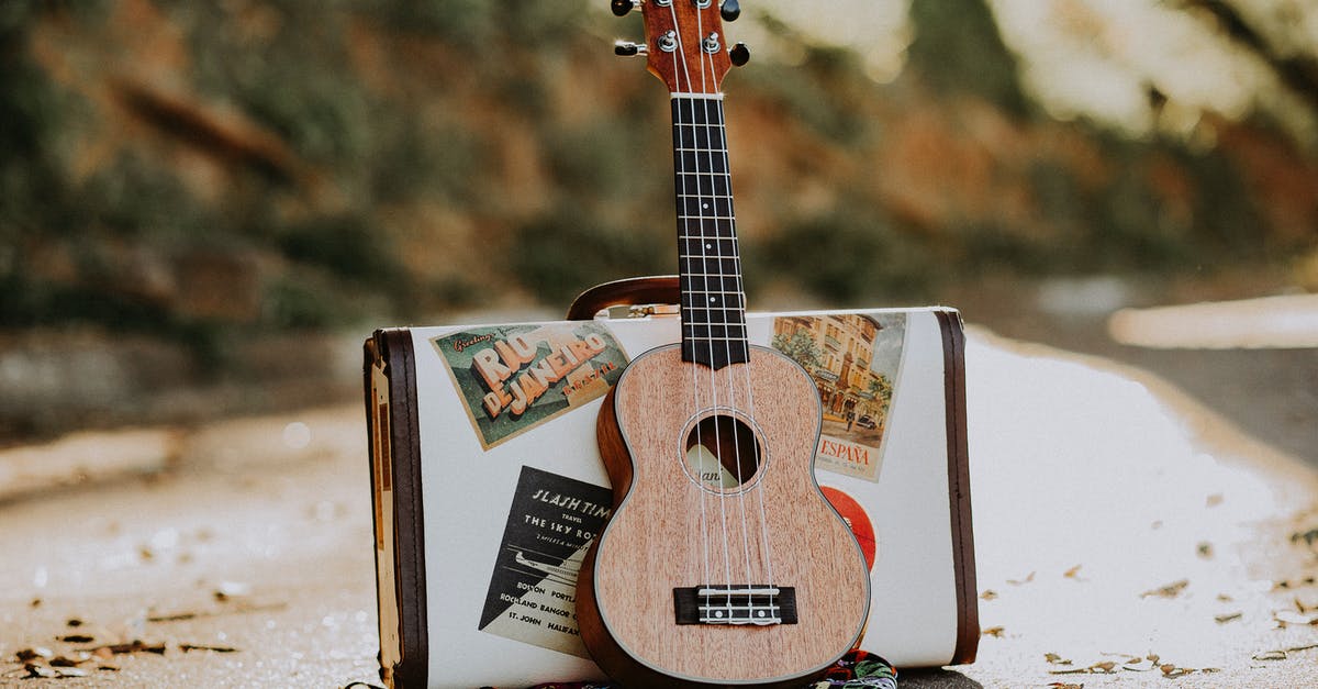 How to replace the in-game music in Asphalt 8: Airborne? - Wooden soprano ukulele placed on asphalt road with stylish suitcase on sunny autumn day