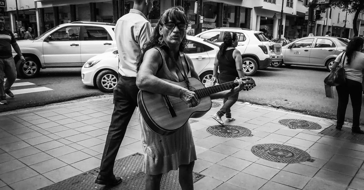 How to replace the in-game music in Asphalt 8: Airborne? - Elderly ethnic female musician playing guitar on city street
