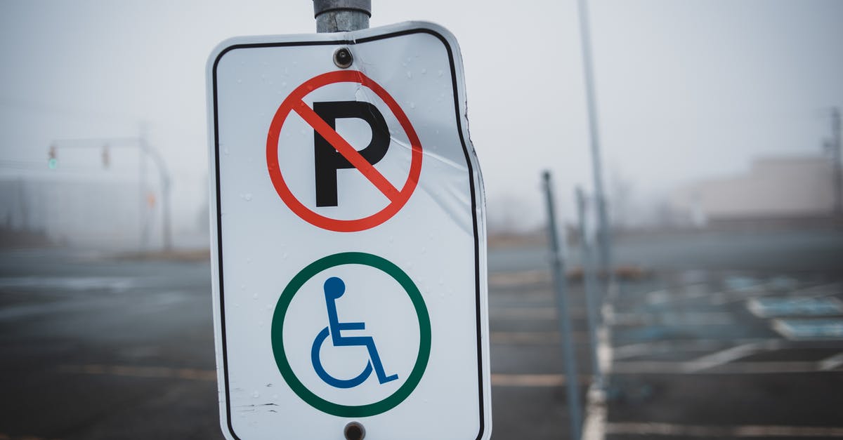 How to restrict areas to specific types of prisoners [duplicate] - White disabled parking sign on post located on empty asphalt parking lot with marking line on street in foggy weather