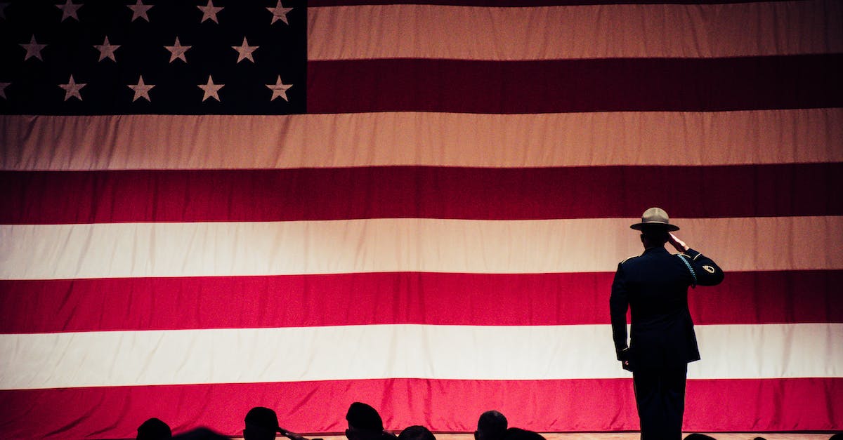 How to salute at team-match end? - Man Standing On Stage Facing An American Flag
