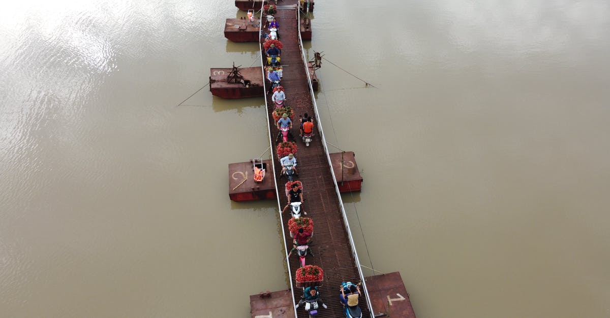 How to sell a ship - People on motorbikes crossing river on floating bridge