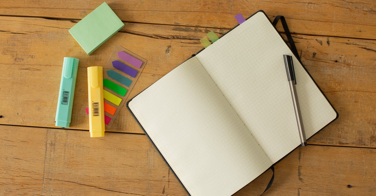 How to set new players into a team? - Top view of opened sketchbook with blank pages and pen with coloured markers and bookmarks arranged on wooden desk