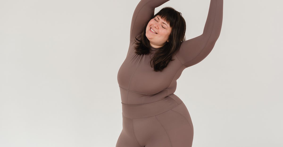 How to shoot big weapons without crouching - Overweight smiling woman in sportswear with raised arms How to shoot big weapons without crouching - Overweight smiling woman in sportswear with raised arms